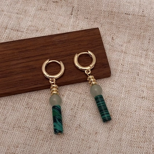 Détail de boucles d'oreilles dorées vintage avec pierre naturelle et pendentifs en marbre