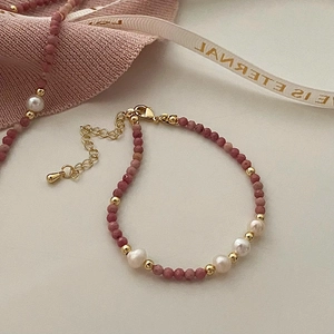 Gros plan d'un collier en perles roses et perles d'eau douce avec fermoir doré