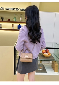 Detalle de bolso acolchado caqui con cierre de giro dorado y solapa elegante