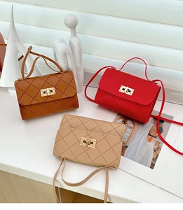 Detalle de tres bolsos bandolera pequeños en marrón, rojo y beige con acolchado