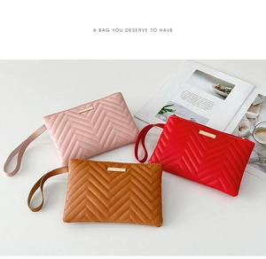 Flat lay of colorful V-quilted clutch bags with golden metal bars and wrist straps