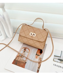 Detalle de bolso bandolera beige acolchado con cierre dorado y asa superior fija