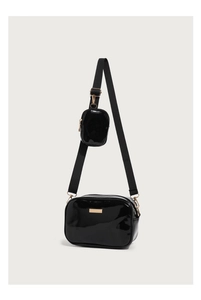 Detail of glossy black PU leather crossbody bag with detachable mini pouch and gold hardware