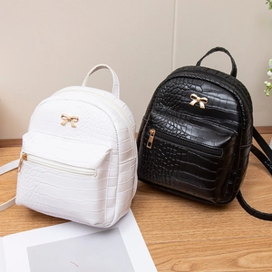 Mini crocodile pattern backpacks in black and white with gold bow buckle accents