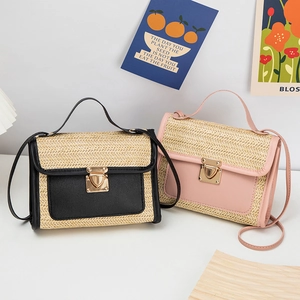 Close-up of woven straw crossbody bags with contrast leather trim and golden metal buckles