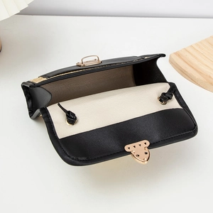 Detail showing the internal storage and gold metal clasp of the woven leather bag
