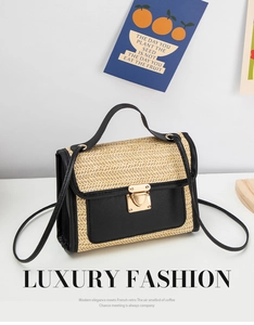 Detail of woven straw handbag featuring black leather trim and gold metal clasp