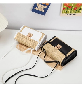 Detailed view of straw-woven crossbody bags with leather trim and gold metal locks
