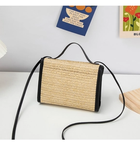 Close-up of woven straw texture and black leather trim on a summer crossbody bag