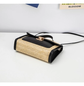 Detail of woven straw crossbody bag featuring black leather trim and gold twist lock closure