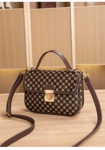 Detail of vintage brown printed handbag featuring heart-shaped gold buckle and handle