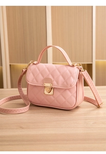 Detail of pink quilted handbag showing gold lock hardware and scalloped shoulder strap