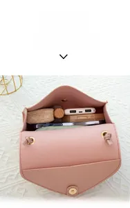 Capacity display of light pink crossbody bag with metal ring detail showing internal storage