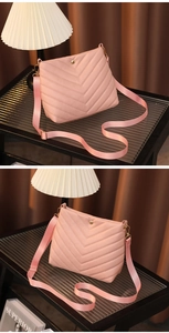 Detail of pink PU leather bucket bag featuring V-shaped quilted embroidery and gold hardware