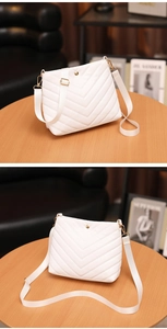 Close-up of white PU leather bucket bag featuring elegant V-shaped chevron quilted texture