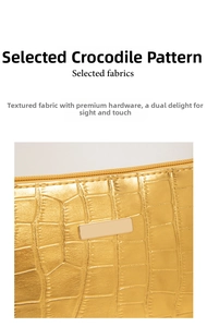 Nahaufnahme der goldenen Kroko-Textur und Metallplakette an einer modischen Tasche