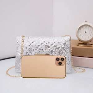 Macro detail of silver sequin crossbody bag with chain strap and phone for size scale