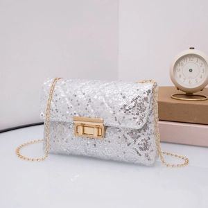 Detailed close-up of silver sequin crossbody bag with gold chain strap and turn-lock