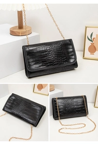 Detailansicht der schwarzen Kroko-Lederhandtasche mit eleganter goldener Kettenriemen