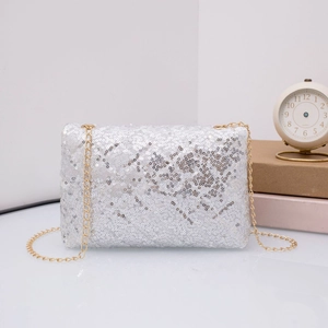Macro detail of silver sequin evening clutch with quilted texture and gold chain strap
