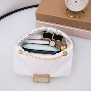 Detail of white sequin crossbody bag interior showing spacious storage for makeup and gadgets
