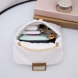 Elegante weiße Stepptasche mit Goldkette und viel Stauraum für Essentials im Inneren