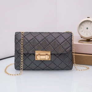 Detail der dunkelgrauen Stepptasche mit goldenem Verschluss und Kettenriemen