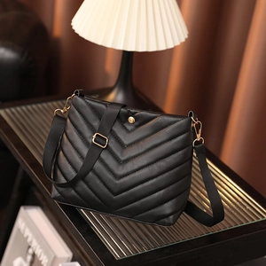 Black PU leather bucket bag featuring V-shaped quilting and wide fabric shoulder strap