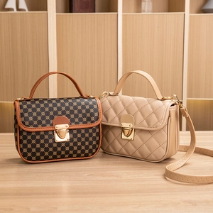 Quilted Kelly bag and monogram pattern handbag on a wooden table with top handles