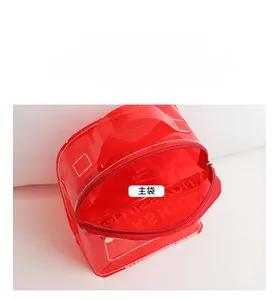 Détail du mini sac à dos en PVC rouge transparent montrant sa capacité de rangement