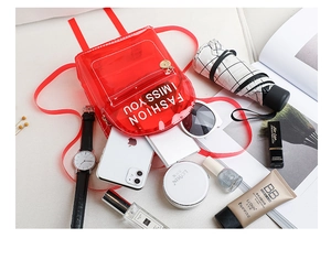 Vue détaillée du sac à dos en PVC rouge transparent avec rangement pour téléphone et maquillage