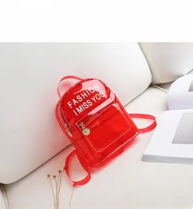 Détail d'un mini sac à dos en PVC rouge transparent avec imprimé slogan de mode blanc
