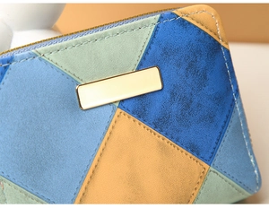 Macro shot of faux suede patchwork wallet with stitching and gold metal plate