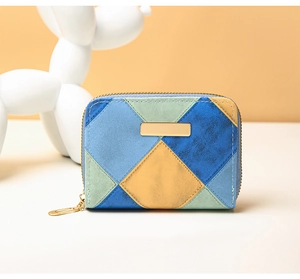 Macro shot of patchwork quilted coin purse with matte leather and gold metal plate detail
