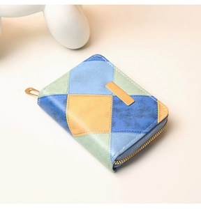 Detail of color-block patchwork coin purse with sequin accents and gold hardware zipper