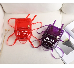 Détail de mini sacs à dos en PVC transparent rouge et violet avec fermetures éclair dorées