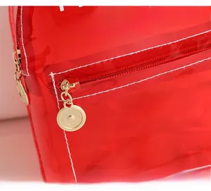 Gros plan des coutures blanches et fermetures éclair dorées sur sac en PVC rouge