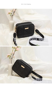 Detalle de bolso acolchado negro con cremallera dorada y correa de jacquard