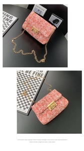 Detalle de bolso bandolera de tweed rosa coral con cadena dorada y cierre metálico