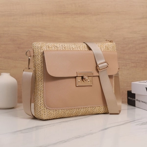 Detail einer gewebten Strohhandtasche mit Lederklappe und goldenem Steckschloss