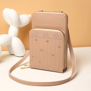 Détails de broderie papillon sur un mini sac à bandoulière beige avec fermetures dorées