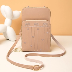 Détails de broderie papillon et cœur sur un sac à bandoulière en cuir rose pour téléphone