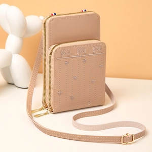 Détail du sac de téléphone beige avec broderie élégante de papillons et de cœurs