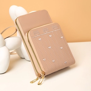 Détail d'une pochette rose pour téléphone avec broderie cœur et zips dorés élégants