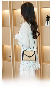 Detail of straw crossbody bag with pearl tassel, contrast leather trim and metal lock