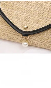 Macro detail of straw woven texture with golden metal clasp and white pearl tassel pendant