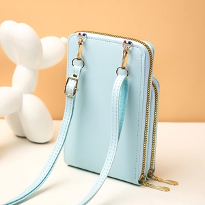 Détail de la pochette téléphone bleu clair texture litchi avec fermeture dorée