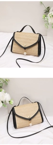 Detail of straw woven bag with black leather trim and white pearl tassel charm