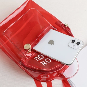 Sac à dos en PVC rouge transparent motif 'ON YOU' montrant le rangement d'un smartphone blanc