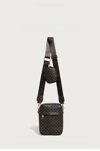 Detail view of dark brown textured crossbody bag with matching round pouch and wide strap